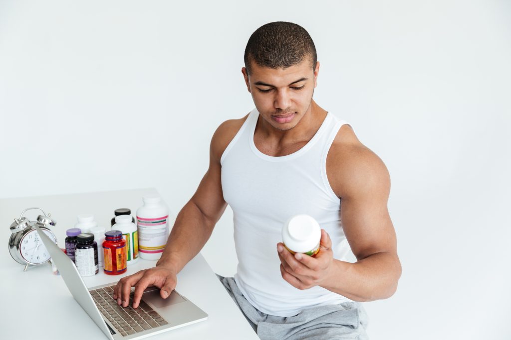 Does Turkesterone Affect Testosterone? A Close Look at The Science 2 handsome young sportsman holding sport nutrition using laptop computer
